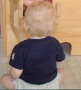 a happy baby with cloth diaper on is playing with his big sister
