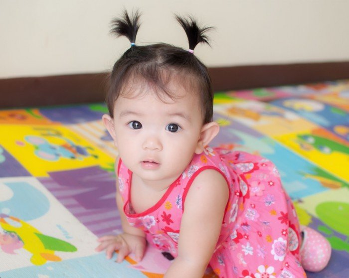 Baby girl in flowers and pigtails