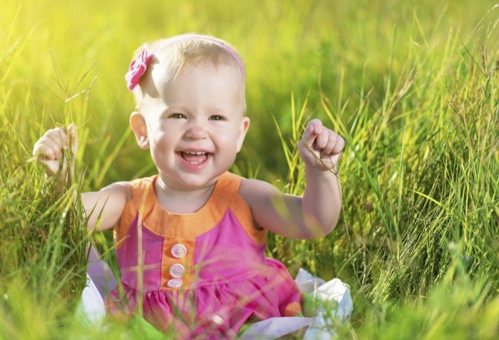 Happy baby girl plays outside