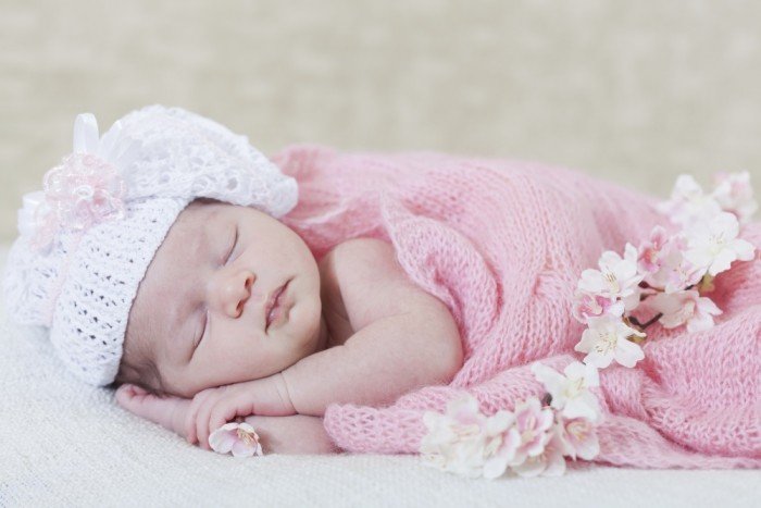 Sleepy little newborn strewn with flowers