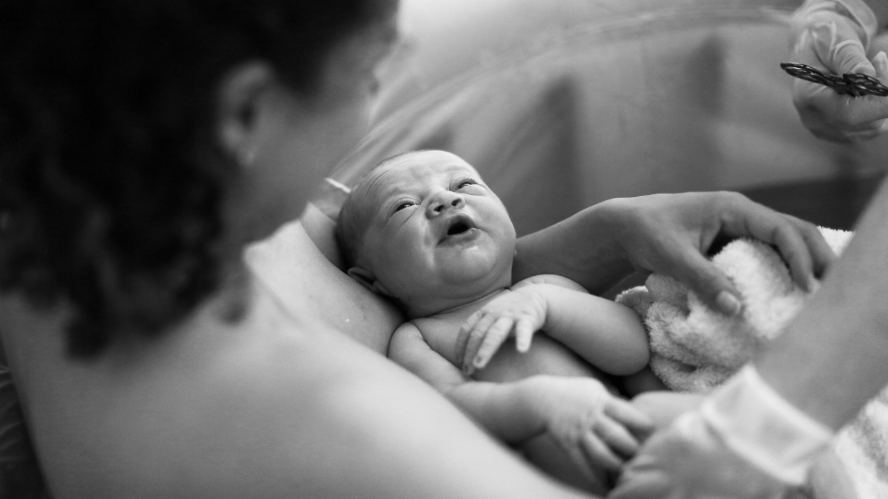 Mother holds newborn in water