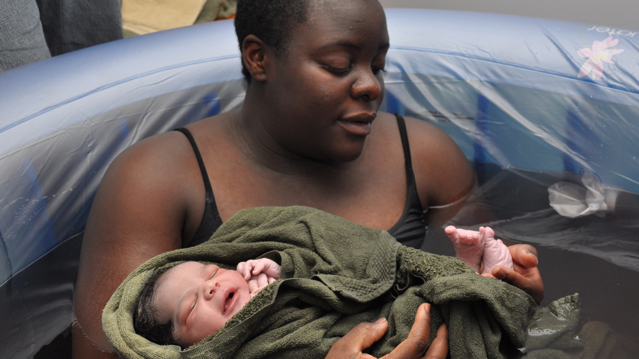 Mother counts newborns toes in birth tub