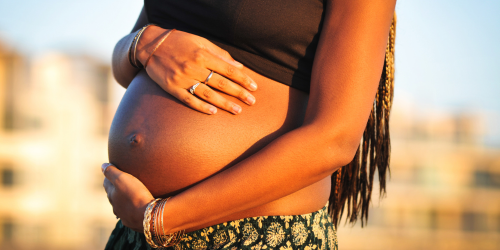 Evidence for Complicated Pregnancies Black mother holds her belly