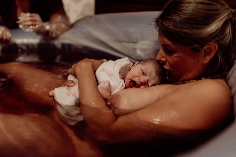 Mother holding newborn after waterbirth